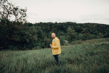a man in a yellow raincoat with a camera