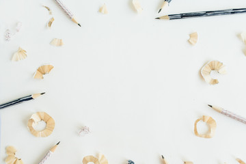 Round frame of pencils and shavings on white background. Flat lay, top view art concept.