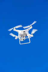 Quadcopter drone with the camera against the blue sky