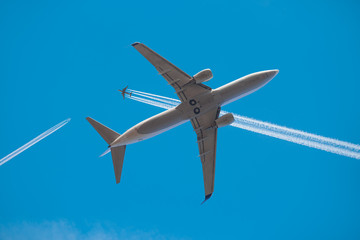 Trail of white smoke from the airplane on blue sky, Plane traffic