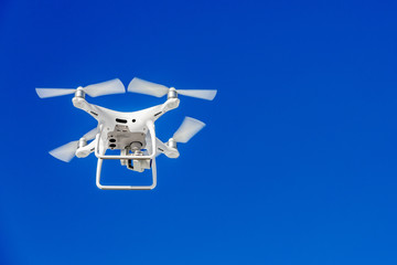 Quadcopter drone with the camera against the blue sky