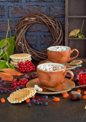 two brown cups of cofeeand cookies