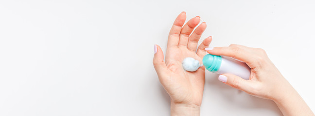 Woman moisturizing her hands with foam lotion