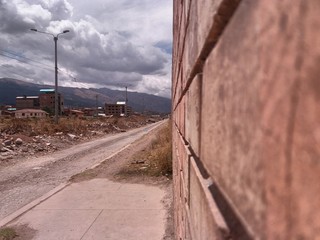  nearby bricks, dirt track to side, cloudy sky background, location cusco, peru.