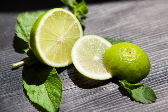 Lime and mint as ingredients for lemonade or mojito, food on black background