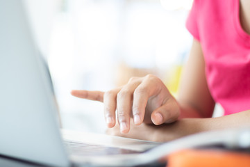 The hand of a woman typing the laptop.