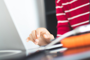 The hand of a woman typing the laptop.