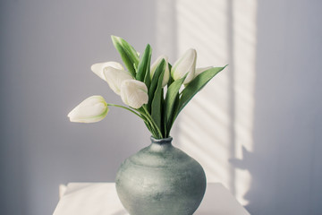 White tulips in a jug on the table - save space - a gift of fresh flowers