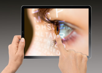 Close-up Of Woman Holding Digital Tablet - Close up of an eye and vision test