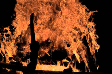 Loderndes Lagerfeuer mit glühenden Flammen verbrennt Holz in der Nacht