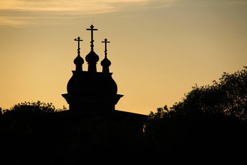 The silhouette of cupolas of Wooden Saint George Church in Kolomenskoe against bright sunset sky