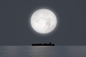 Silhouette of the cargo ship with super moon (moonrise) "Elements of this image furnished by NASA"