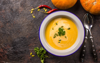 Seasonal autumn food - Spicy pumpkin soup with cream and pumpkin seeds.
