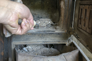 Cleaning an old stove, dispose of ash in the ash box.