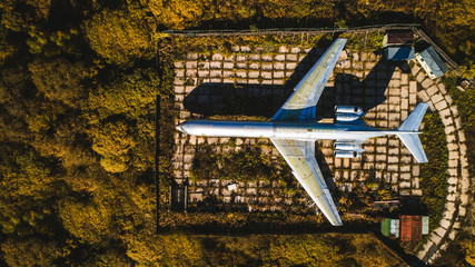 Aerial view of the plane in the autumn forest. Top view. Beautiful autumn landscape with a plane.