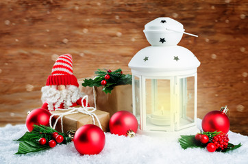 Christmas lantern with gifts, colored balls on a winter wood background