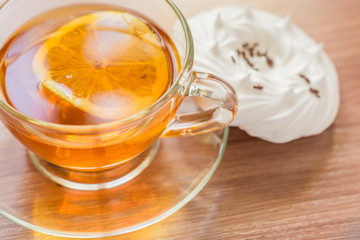 black tea in transparent cup an air homemade meringues close up