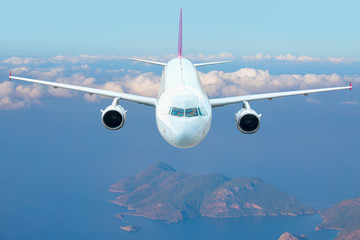 Fototapeta premium Passenger airplane rising up into the sky after taking off from airport