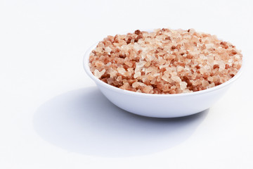 close-up in white container filled with granulated pink salt