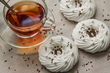 black tea in transparent cup an air homemade meringues close up