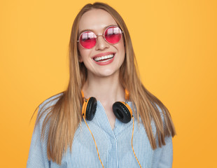 Trendy hipster woman in headphones and sunglasses