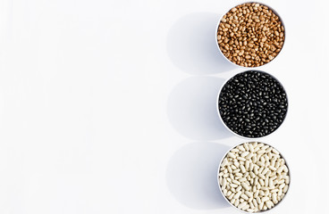 top view of three varieties of beans in bowls, white background