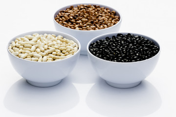 varieties of beans in bowls, white background