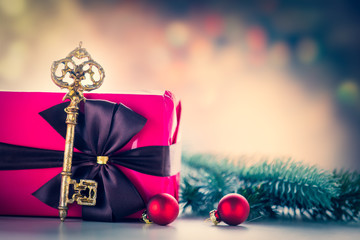 Christmas gift box and key with pine branch on background