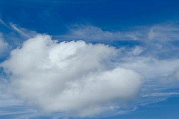 Blue sky with one large, puffy cumulus cloud and some peripheral cirrus clouds.