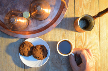 hands take coffee and biscuits from wooden rustic