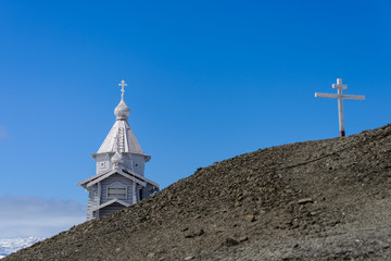 Fototapeta na wymiar Wooden church in Antarctica on Bellingshausen Russian Antarctic research station and helicopter