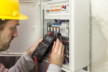 electrician at work measures the electric current - obrazy, fototapety, plakaty