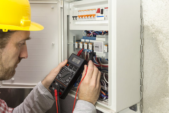 electrician at work measures the electric current