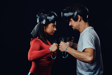  oncept of competition and confrontation. Couple of pro gamers with VR headsets participate in the game battle.