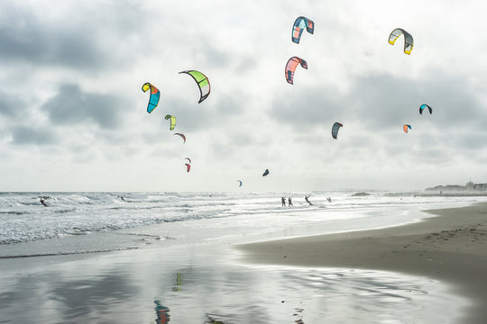 paysage d'automne sur une plage envahie de kitesurf