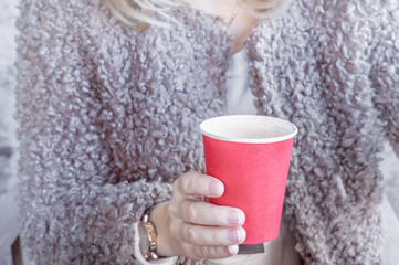 girl holding a red paper Cup of coffee