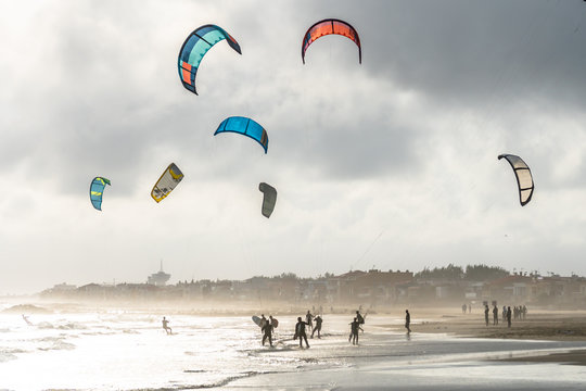 un groupe de kitesurf en bord de plage avec un ciel d'automne