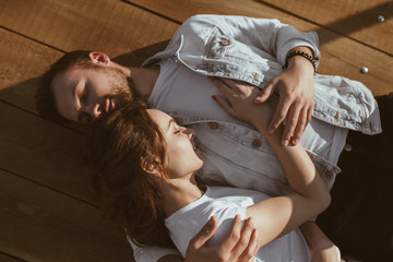 Cute couple sleeping on wooden surface