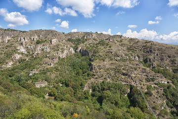 Fototapeta na wymiar beautiful canyon at Khndzoresk cave settlement (13th-century, used to be inhabited till the 1950s) with a suspension bridge underneath, Syunik region, Armenia