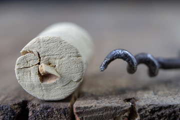 An old corkscrew for wine corks. Open old wine on a wooden kitchen table.
