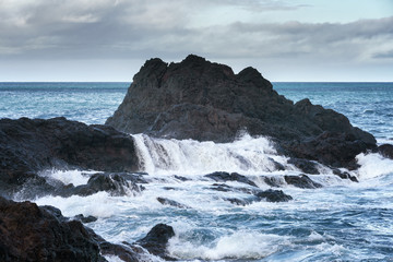Fototapeta na wymiar Seascape with waves crashing on the rocks in Seixal, Madeira