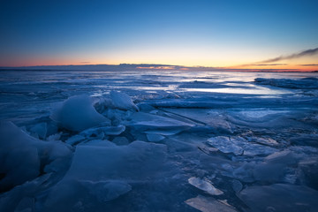 Naklejka na ściany i meble Beautiful winter landscape with sunset fiery sky and frozen lake. Composition of nature.