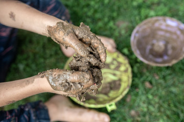 Toddler child playing with mud