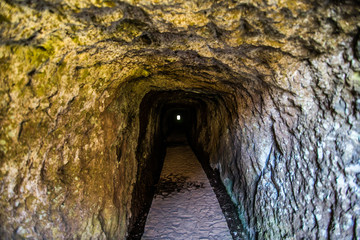Tunnnel on trekking road on Madeira island. A route between two peaks Pico Ruivo and Pico do Areeiro. Amazing cliff view with tourist on the edge