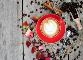 cup of coffee with cinnamon and autumn leaves on an autumn background