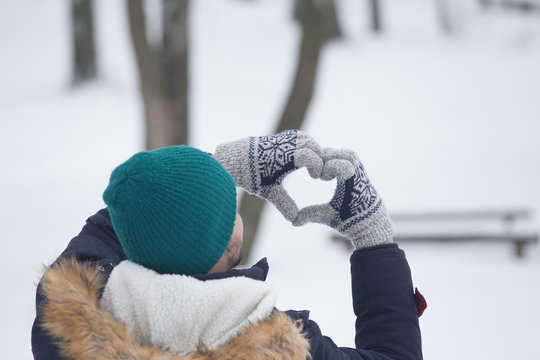 Rear view of man who created heart with hands.