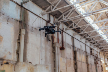 Quad-copter drone with camera flying inside industrial building