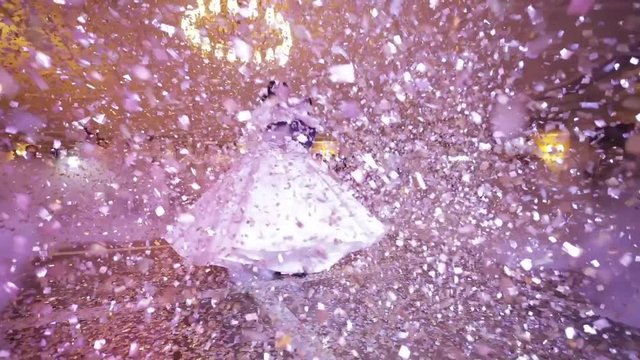First dance of wedding pair in flying gold confetti.