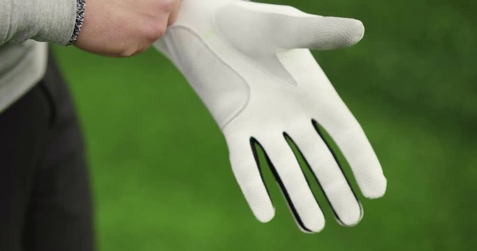 Close up of golfer putting on sports glove