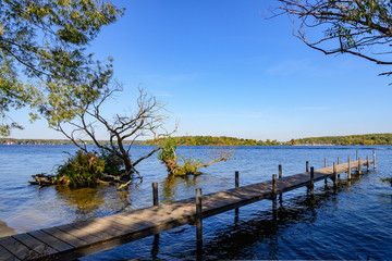 View of waterside and wooden pier on Wannsee lake and Havel river, during sunny day and clear sky...